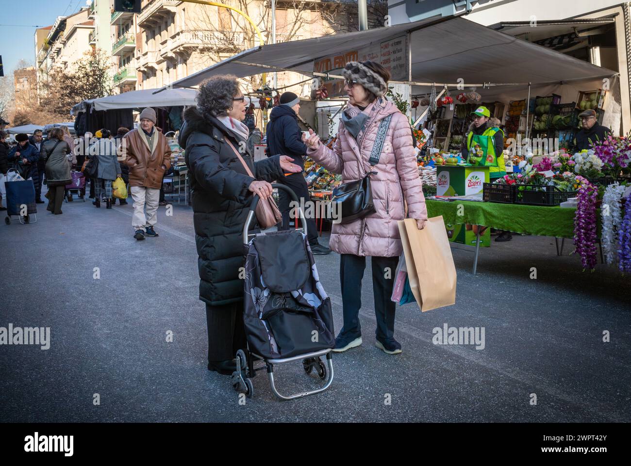 Italienische Frauen halten an, um sich auf dem Fauché Market zu unterhalten, einem großen Freiluftmarkt in Mailand, Italien. Stockfoto