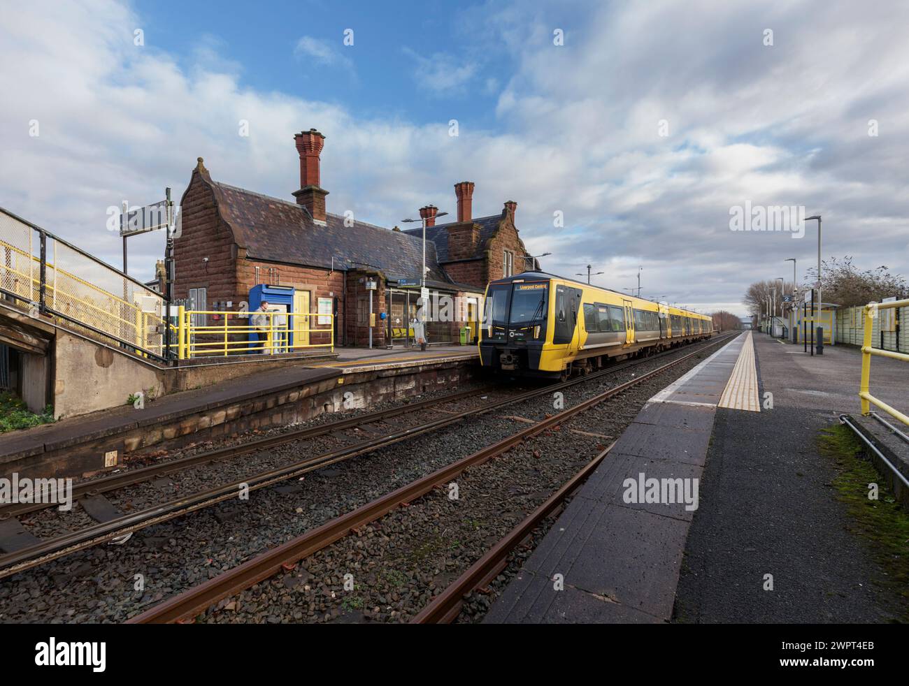 Merseyrail Stadler Baureihe 777 Elektrozug 777006 am Bahnhof Ellesmere Port in Cheshire, Großbritannien mit den Bahnhofsgebäuden Stockfoto