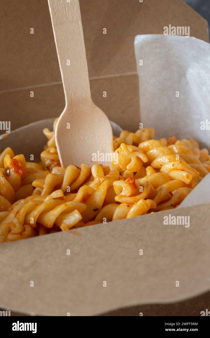 Fusilli-Pasta in Tomaten- und Kräutersoße zum Mitnehmen in einem Karton-Behälter. Biologisch abbaubarer, kunststofffreier, umweltfreundlicher Behälter zum Mitnehmen Stockfoto