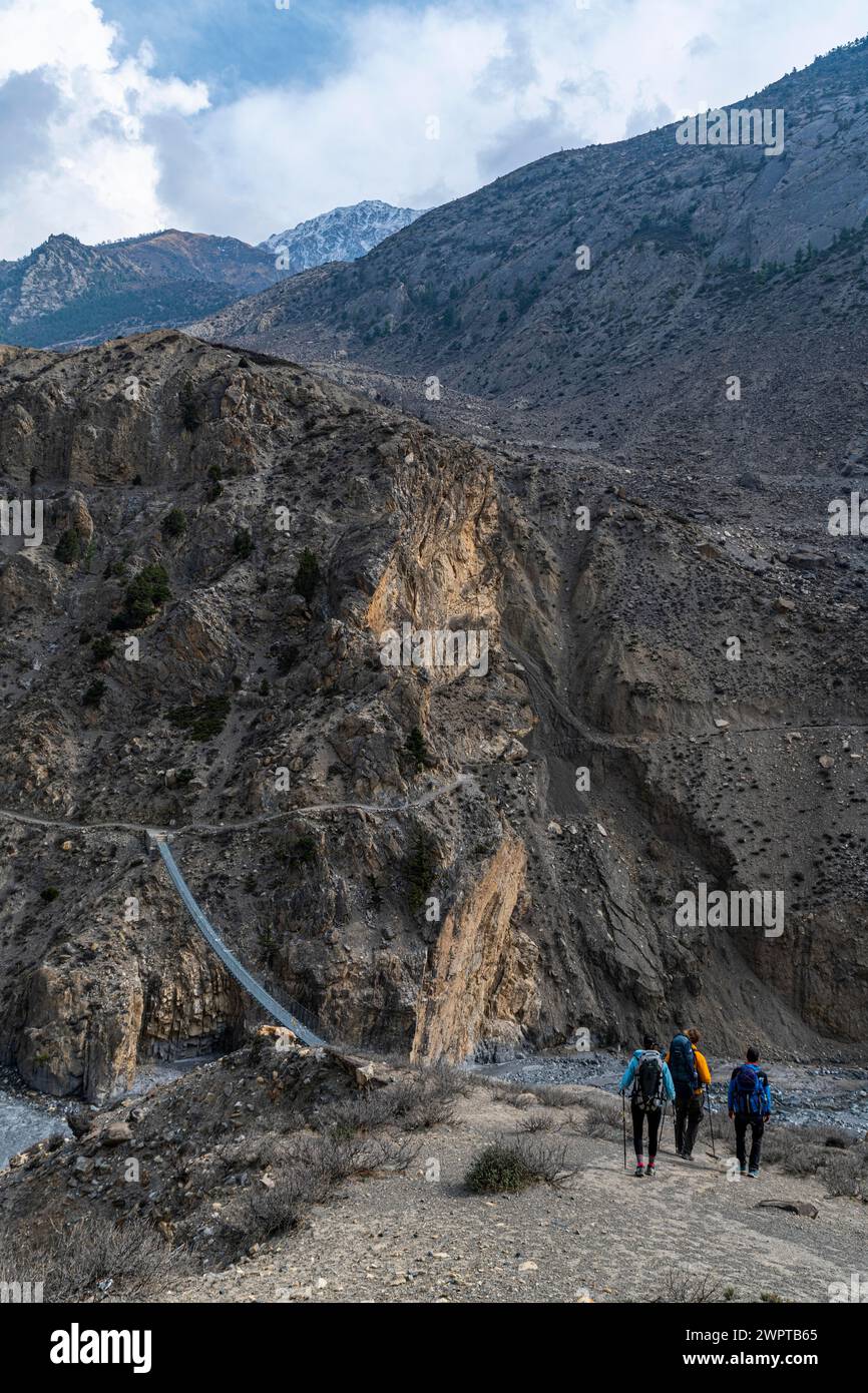 Touristen wandern auf einer riesigen Hängebrücke, Königreich Mustang, Nepal Stockfoto