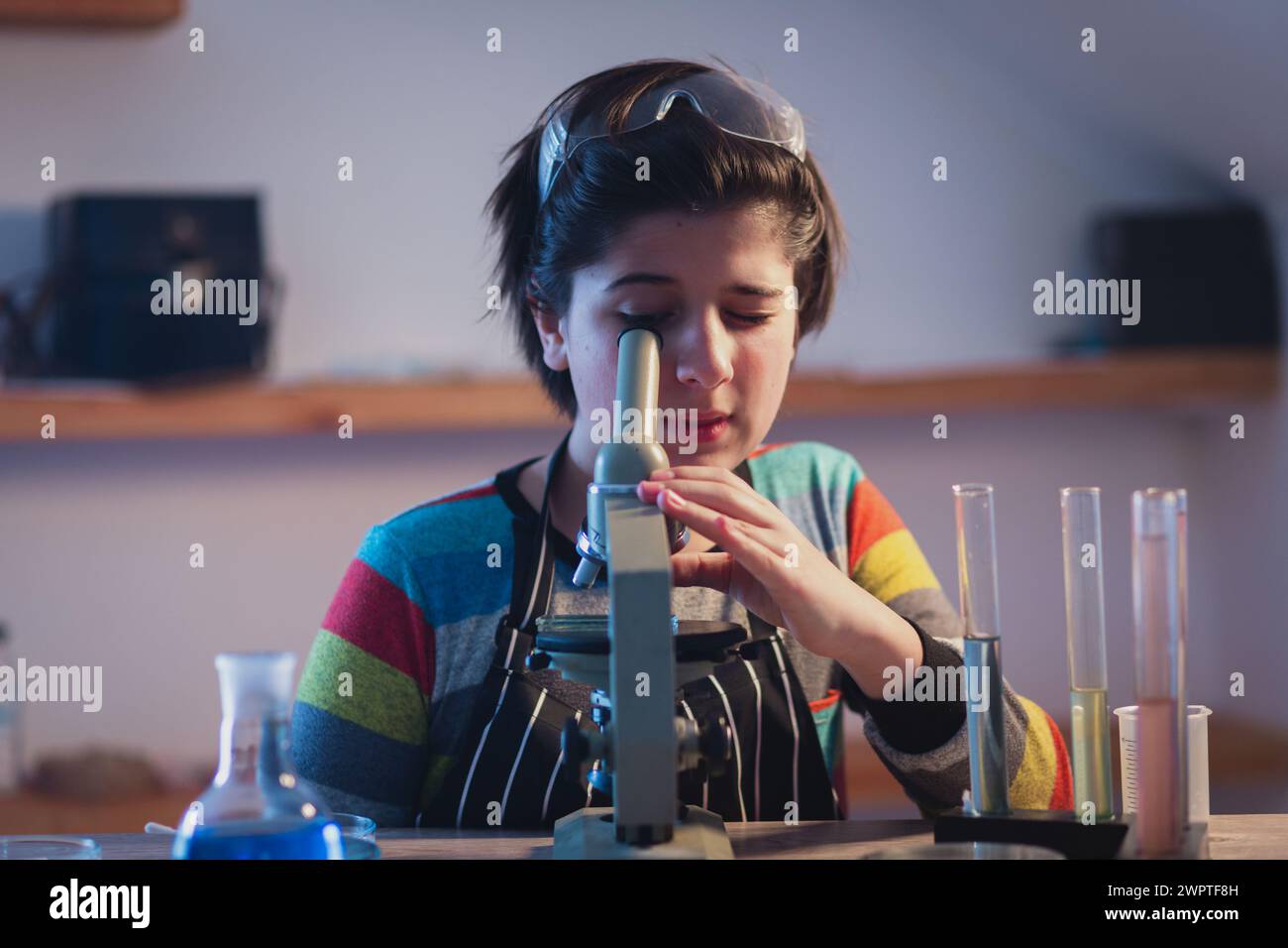 Hobbys und Freizeit. Modernes Bildungsprogramm inklusive Praxisunterricht. Ein junger Forscher in einem Heimlabor mit Schutzbrille arbeitet in Stockfoto