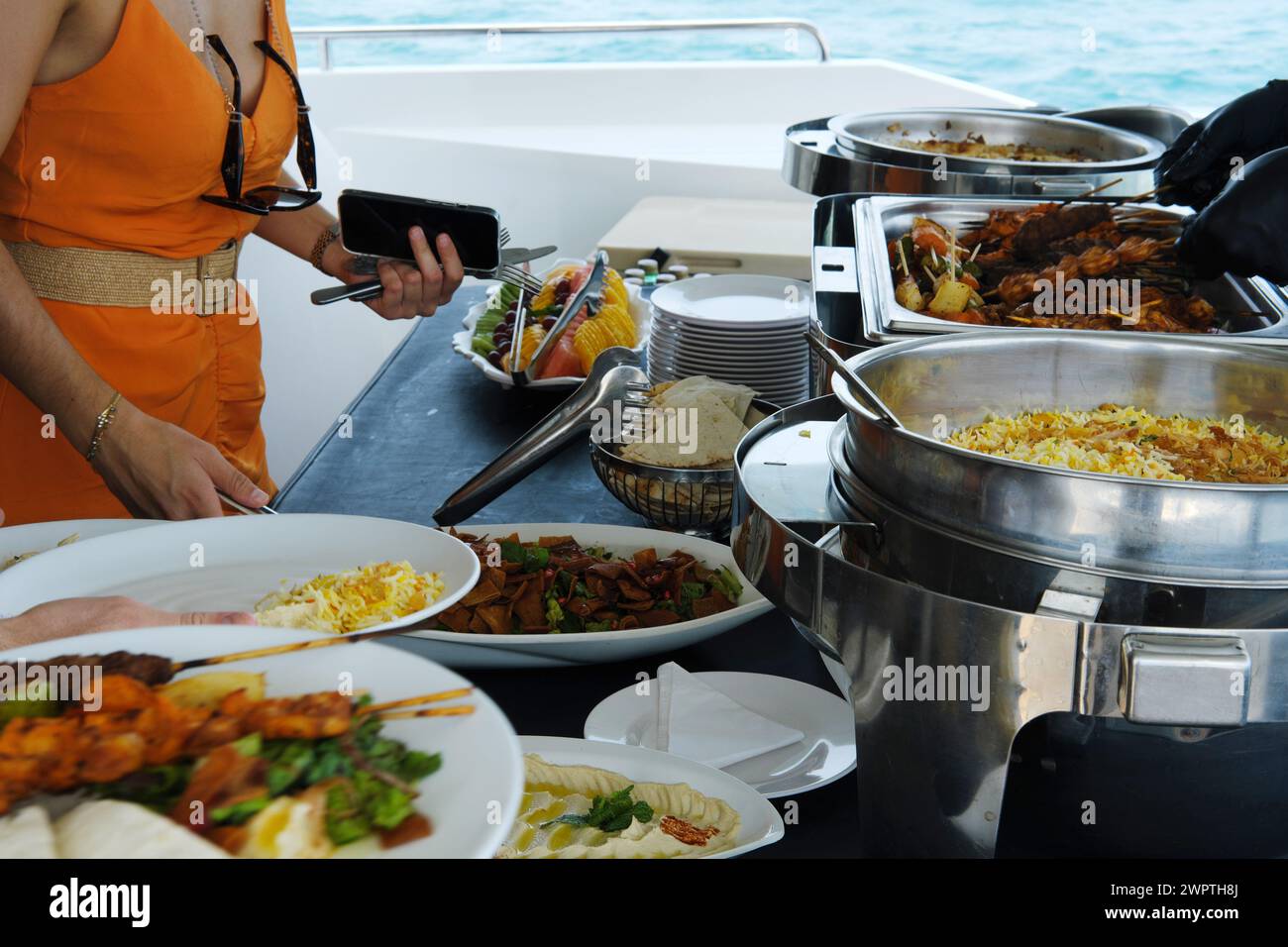 Yachtgäste in Dubai werden an einem sonnigen Tag ein Gourmet-Buffet mit verschiedenen Gerichten serviert Stockfoto