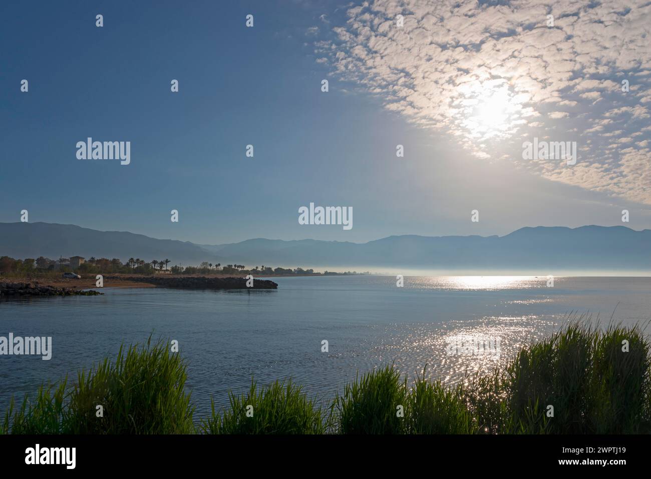 Ein friedlicher Sonnenaufgang über einer Küstenlandschaft mit Wolken am Himmel und ruhigem Meer, Mündung des Flusses Pamisos, Messini, Messinien, Peloponnes, Griechenland Stockfoto