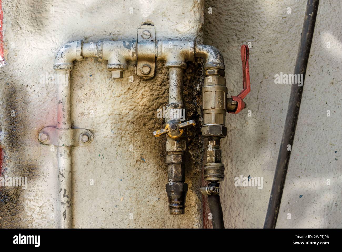 Nahaufnahme eines rustikalen Druckluftanschlusses, an eine raue Wand genagelt, in einer Autowerkstatt in der Stadt Arcabuco in Kolumbien. Stockfoto