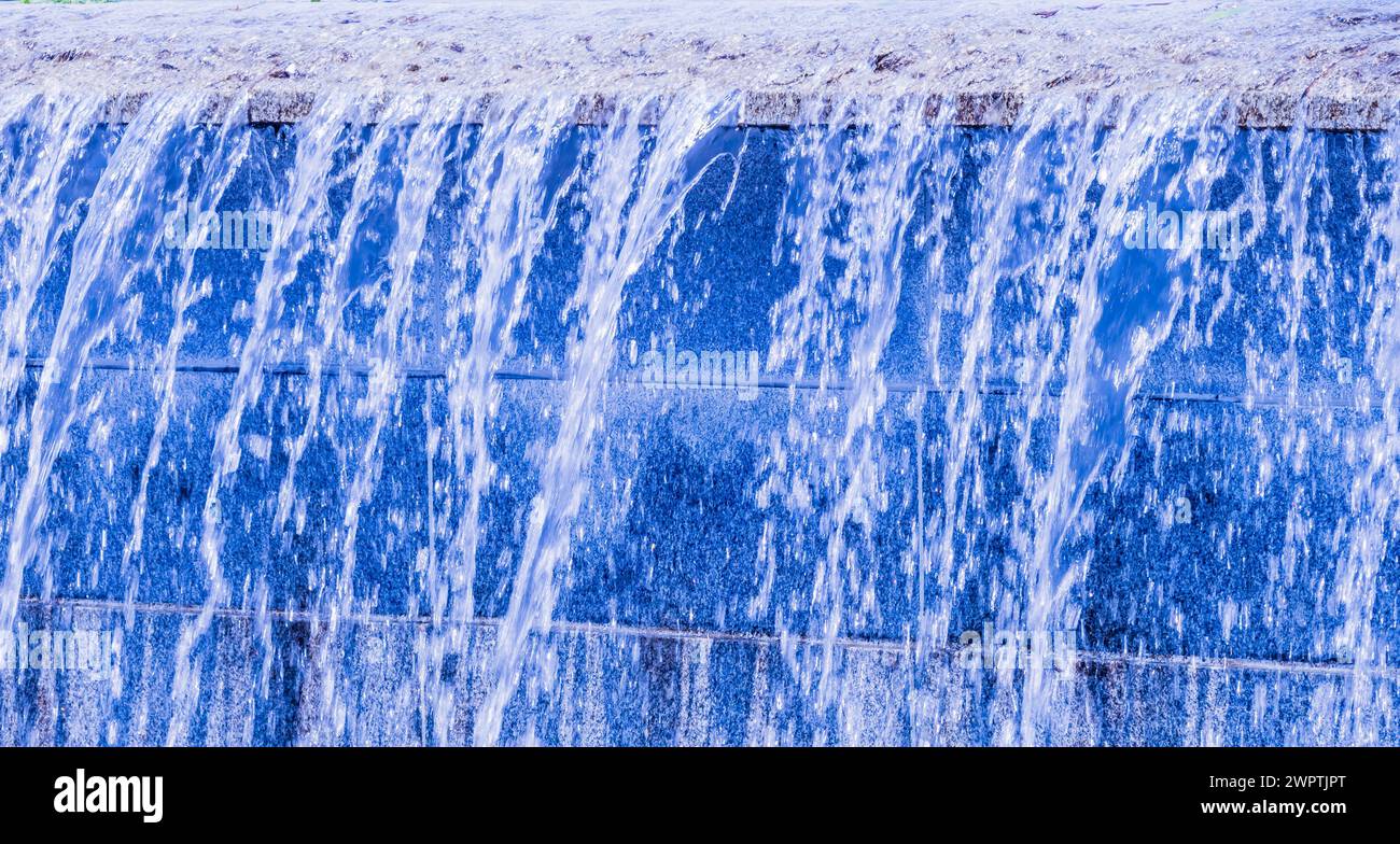 Blauer, künstlicher Wasserfall, der eine Wand hinunter strömt, in Südkorea Stockfoto