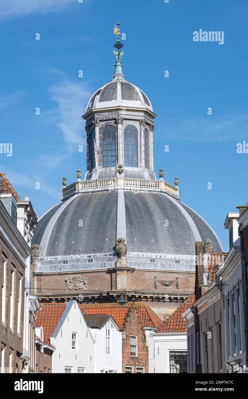 Die Kuppel eines alten Gebäudes erhebt sich in den blauen Himmel über den Gebäuden der Stadt Middelburg, Zeeland, Niederlande Stockfoto