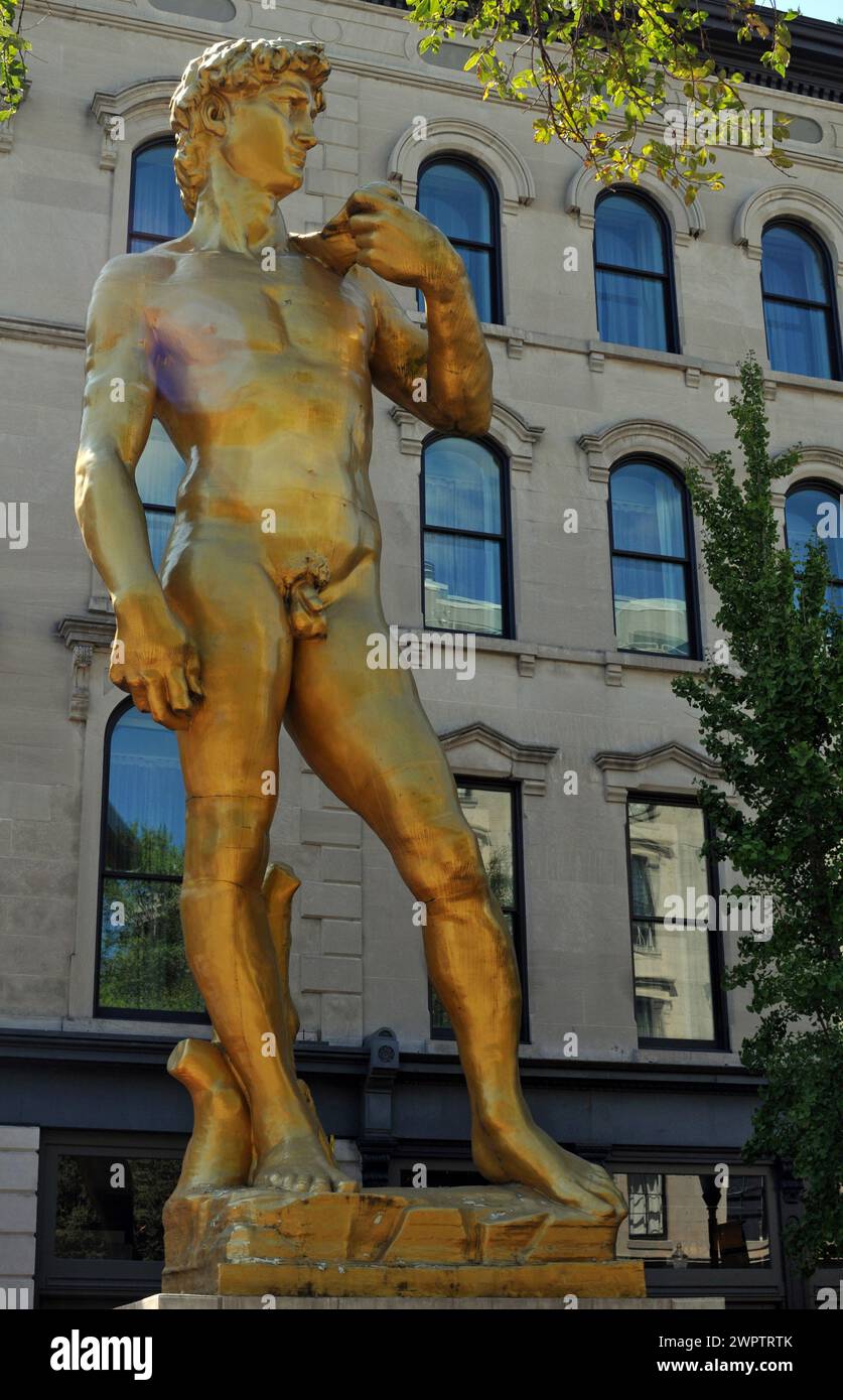 Eine goldene Reproduktion von Michelangelos David-Skulptur des türkischen Künstlers Serkan Özkaya steht vor dem 21c Museum Hotel in der Innenstadt von Louisville. Stockfoto