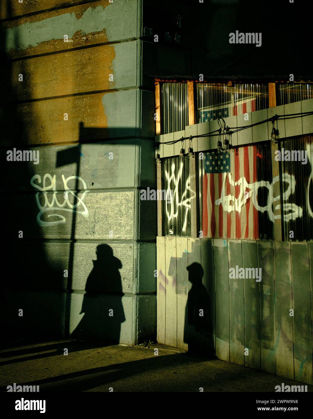 Schatten von Menschen, die auf der Straße vorbeikommen, Elmhurst, Queens, New York Stockfoto