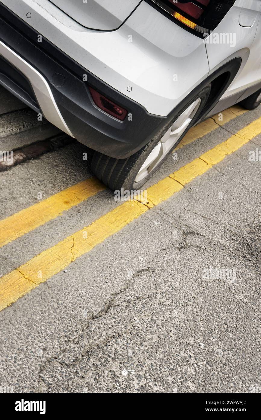 Ein Fahrzeug, das in Großbritannien auf zwei gelben Linien und auf dem Bürgersteig geparkt ist. Stockfoto