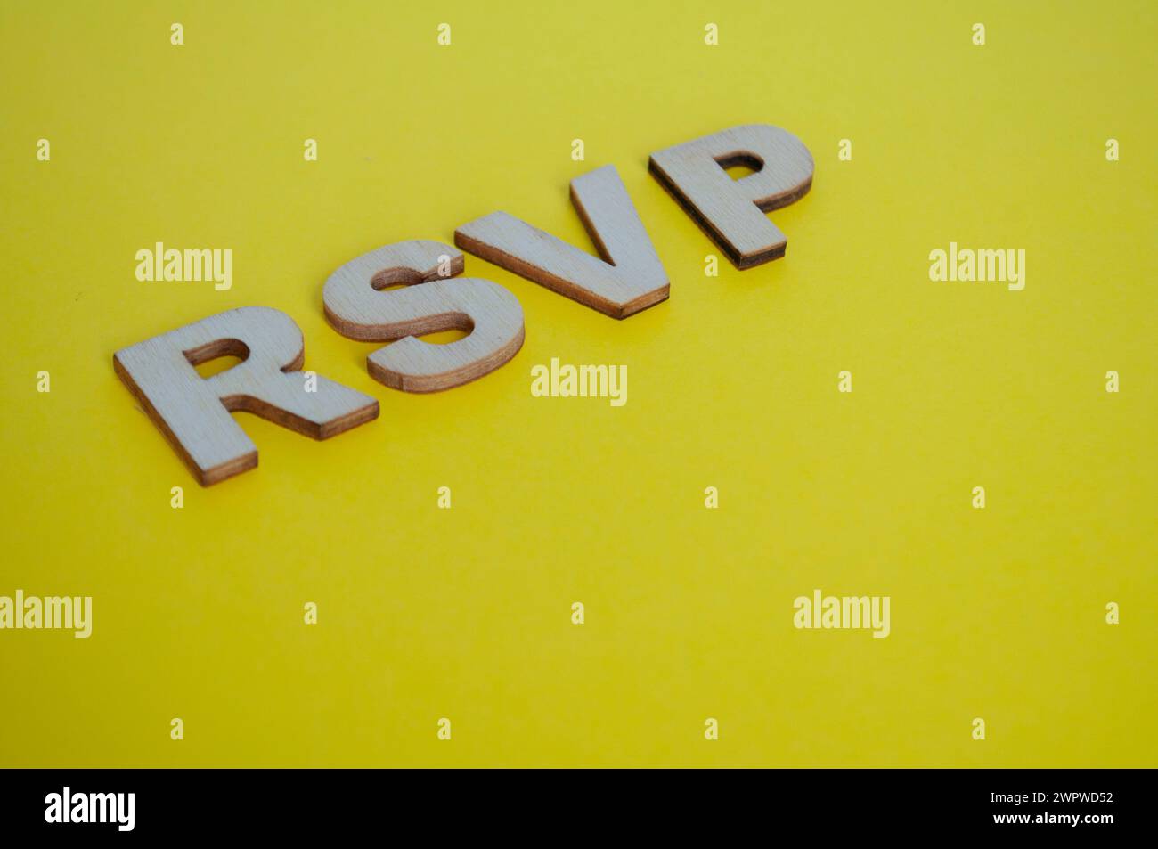RSVP Holzbuchstaben, die „Bitte antworten Sie auf gelbem Hintergrund“. Stockfoto