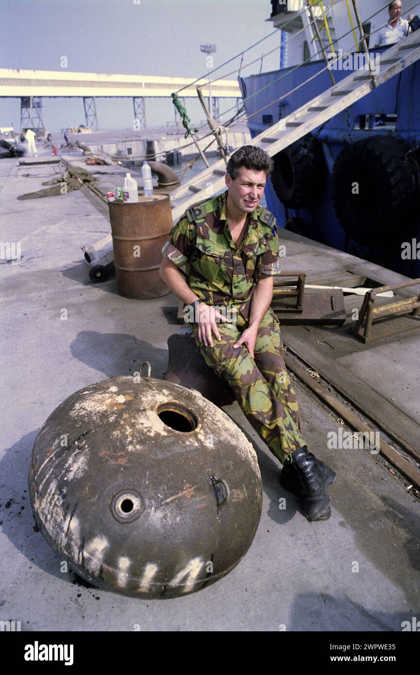 Erster Golfkrieg: 20. März 1991 am Hafen von Shuaiba, Kuwait, sitzt ein Leutnant der Royal Navy auf einer Al-Muthena/45 irakischen Marinemine neben einer behinderten irakischen Tahaddi-Mine. Stockfoto
