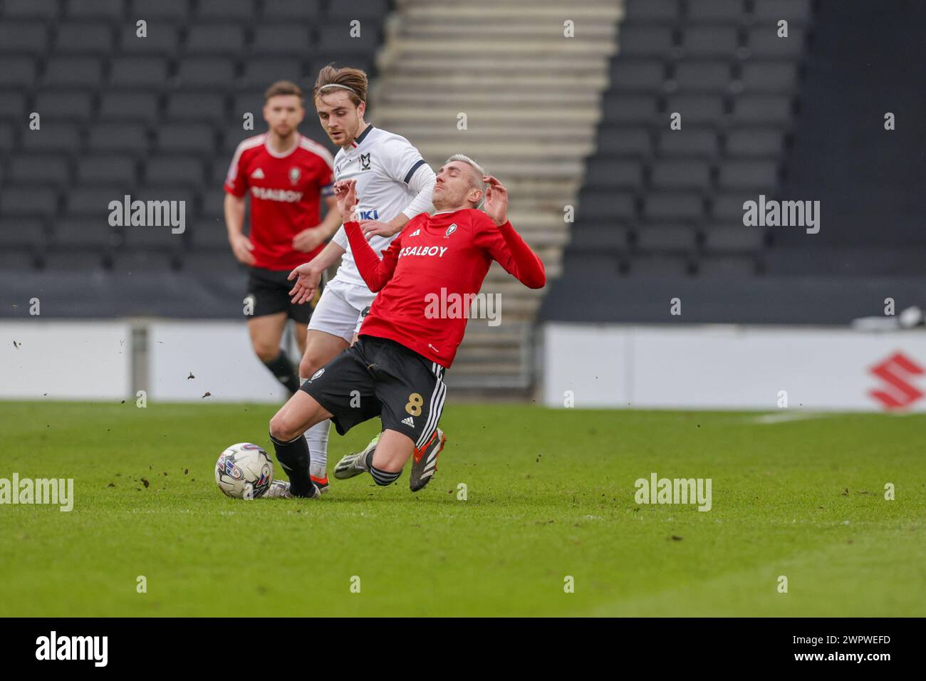 Der Matthew Lund von Salford City wird von Milton Keynes Dons Lewis Bate während der zweiten Halbzeit des Spiels der Sky Bet League 2 zwischen MK Dons und Salford City im Stadion MK, Milton Keynes, am Freitag, den 8. März 2024, angegriffen. (Foto: John Cripps | MI News) Credit: MI News & Sport /Alamy Live News Stockfoto