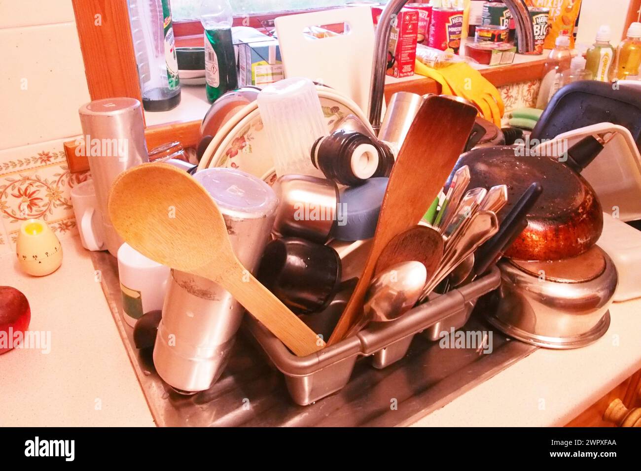 Ein großer Haufen Geschirrspülung auf einem Abfluss mit Töpfen, Pfannen und Utensilien Stockfoto