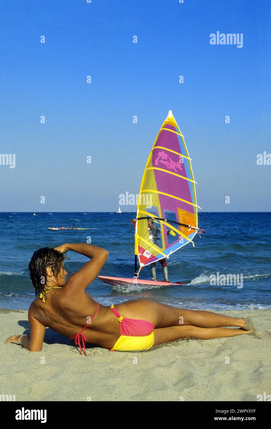 Sport Windsurfer hübsche junge Frau, die auf Sand wartet, aussehend aat Biyfriend Surfen Sommerferien Stockfoto