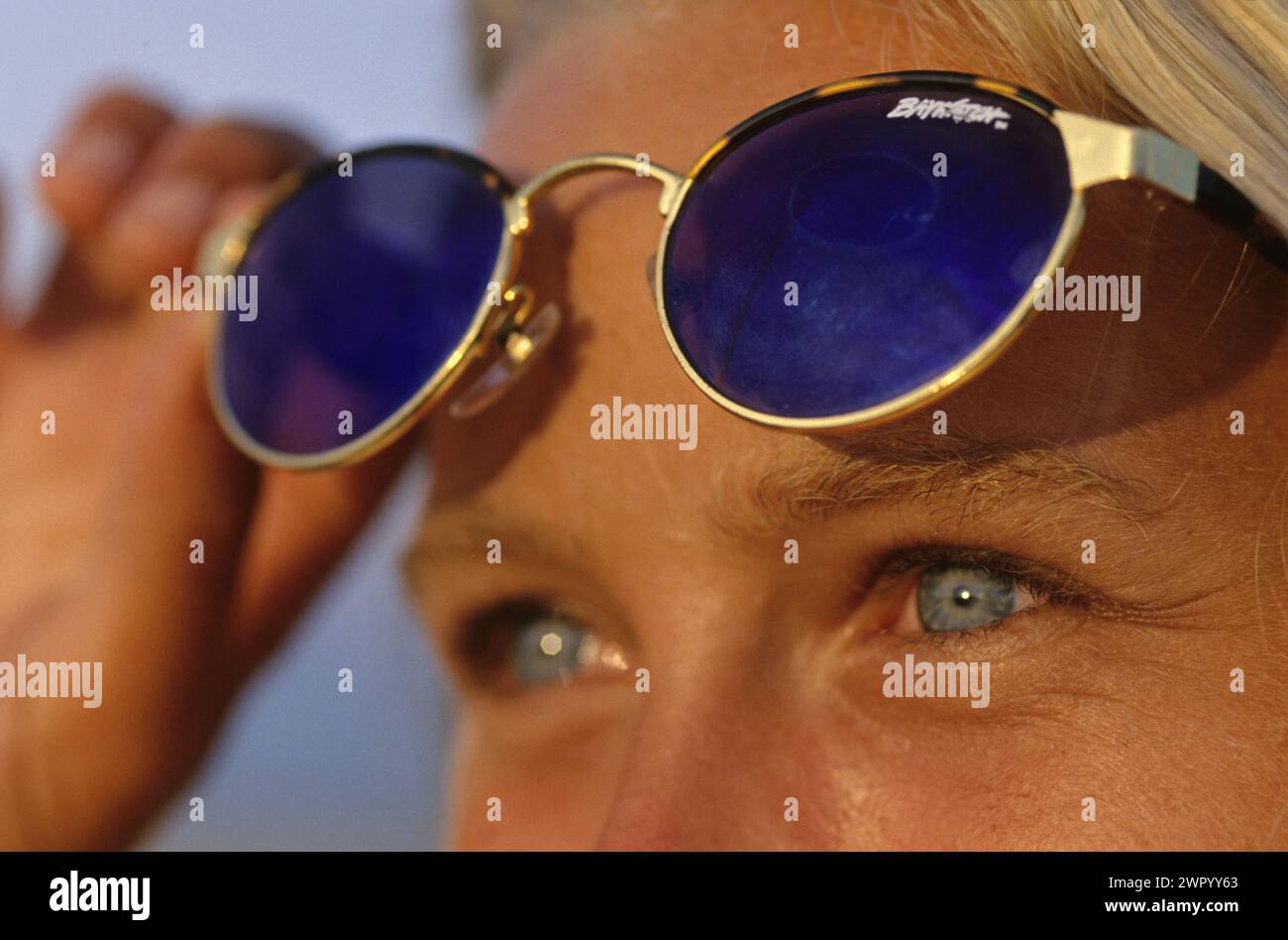 Hübsches junges blondes Haar auf blauen Augen mit Sonnenbrillen-Porträt-Profil, das Horizont sieht Stockfoto