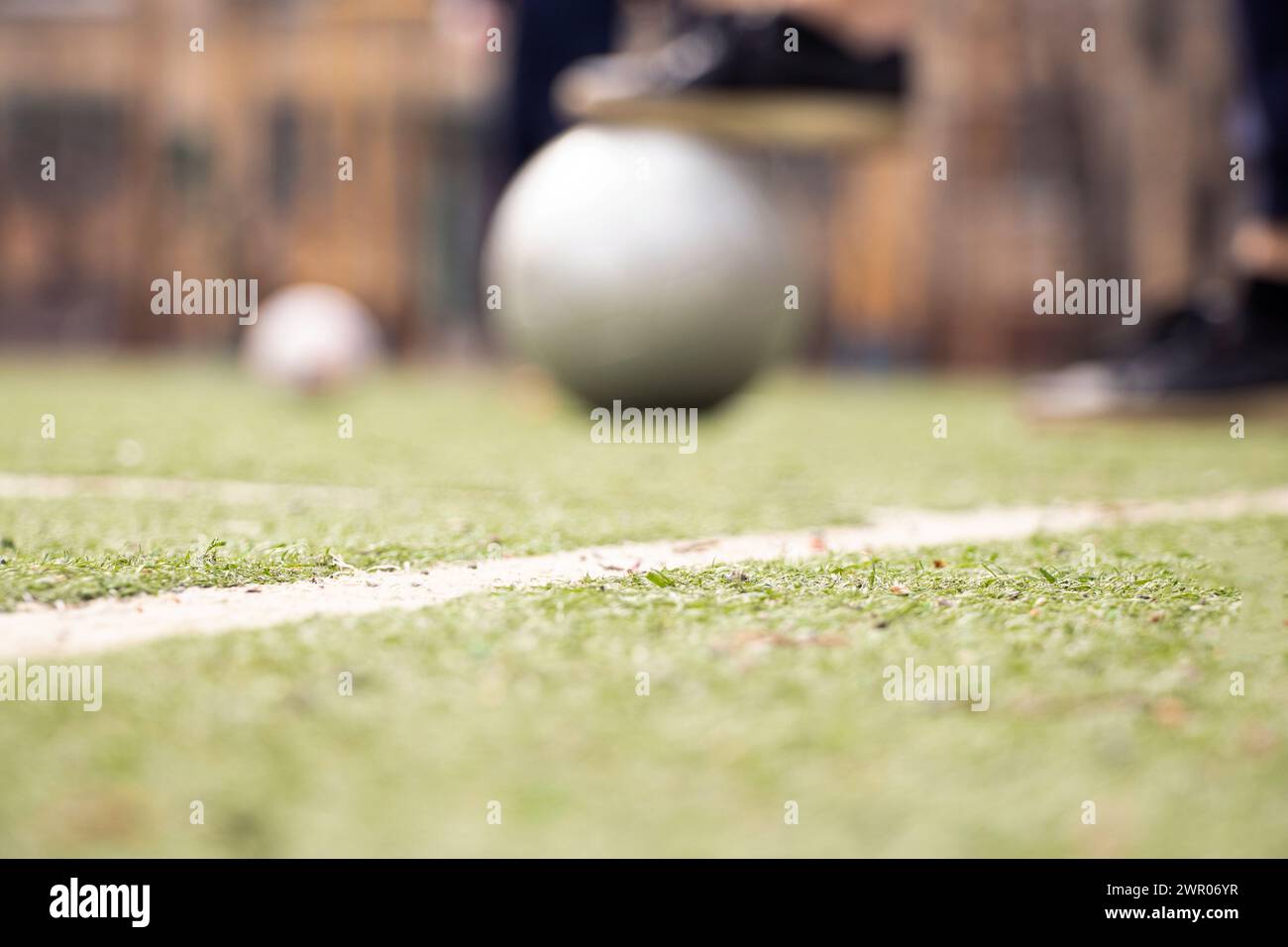 Frauenbeine auf einem Fußballfeld und ein grauer Fußball in der Ukraine, Fußball im Hof spielen, Sport Stockfoto