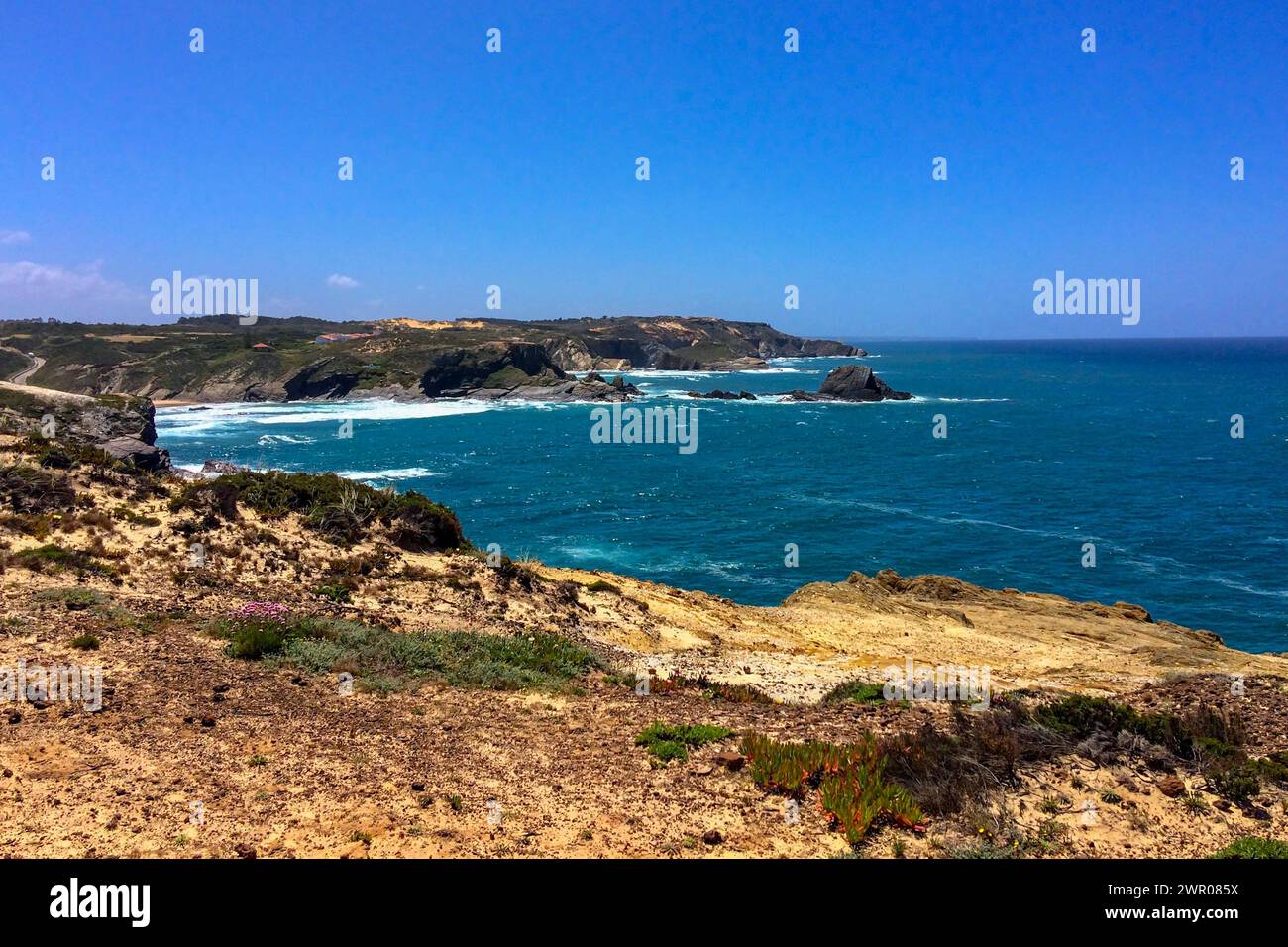 Meereswellen treffen an einem sonnigen Tag auf die zerklüfteten Klippen. Stockfoto