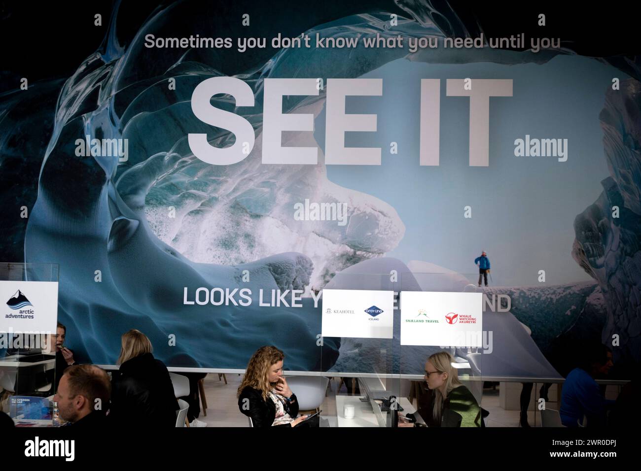 ITB Reisemesse Berlin Deu, Deutschland, Berlin, 06.03.2024 Besucher und Haendler vor Slogan See it am Stand von Island in der Halle Europa auf der Internationalen Tourismusboerse ITB 2024 in Berlin Deutschland . Die ITB stehen in diesem Jahr unter dem Motto gemeinsam die Transformation in Reisen und Tourismus führen . Ueber 5,500 Unternehmen aus 165 Laendern nahmen an der Messe Teil für die globale Vertretung und Zusammenarbeit innerhalb der Tourismusbranche en: Besucher und Händler vor dem Slogan sehen es am Islandstand in der Europahalle der Internationalen Tourismusbörse Stockfoto
