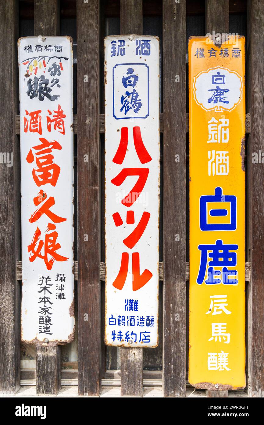 3 Vintage rostende schmale Metallschilder, die verschiedene Marken von japanischem Bier warnen, die an einen Fensterrahmen aus Holz mit Lattenrost in Tatsuno, Japan, genagelt wurden. Stockfoto