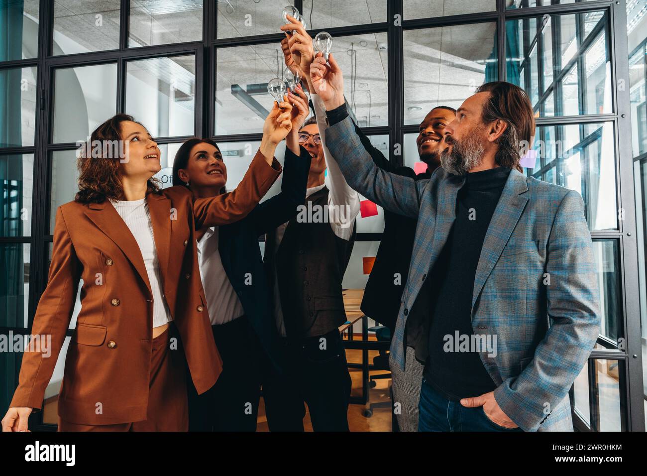 Teamwork und Brainstorming-Konzept mit Geschäftsleuten, die eine Idee mit einer Lampe teilen Stockfoto