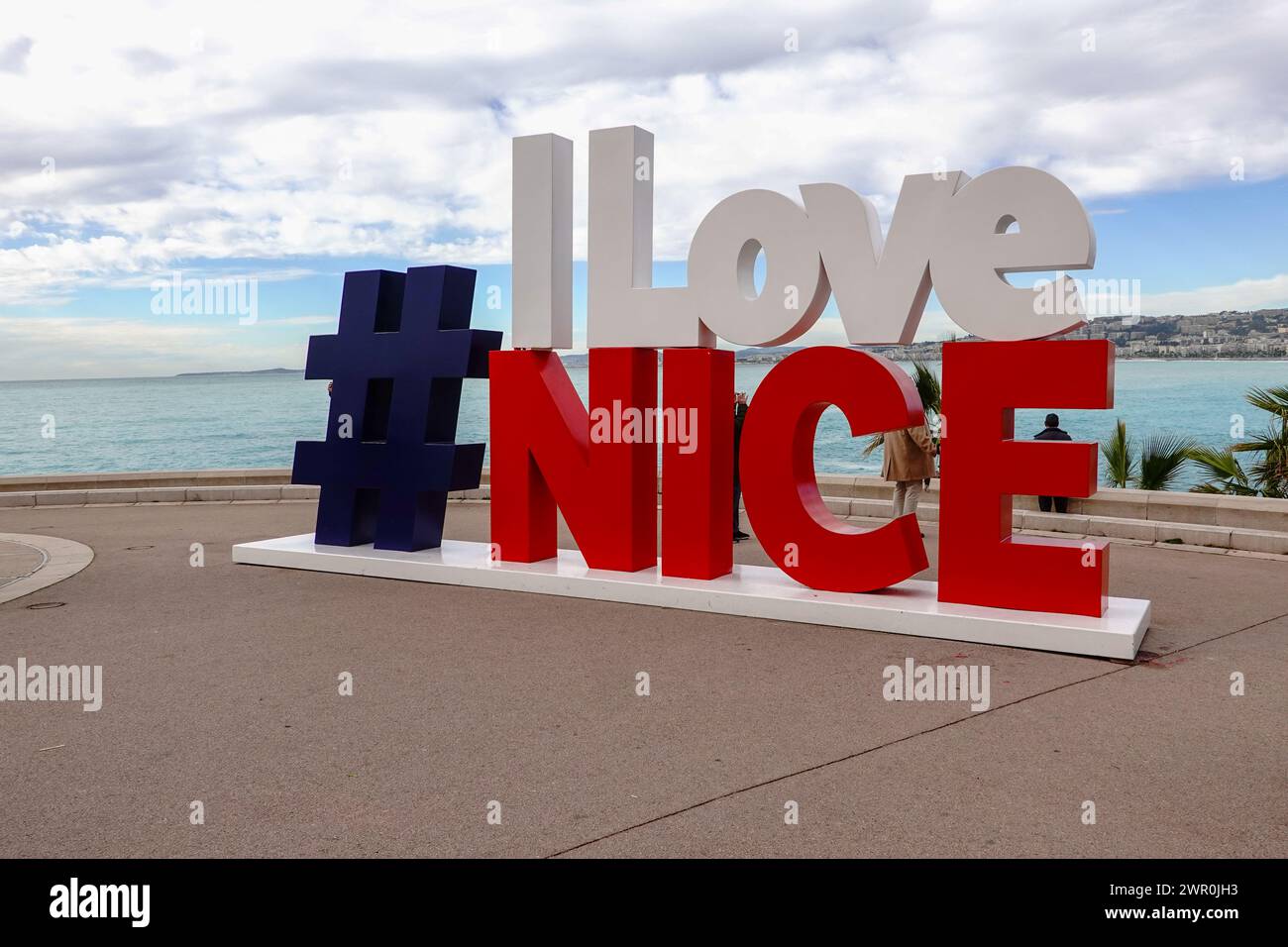 Menschen mit Blick auf die Mittelmeerküste in der Nähe des Wahrzeichens „I Love Nice“, Côte d’Azur, Nizza, Frankreich. Stockfoto