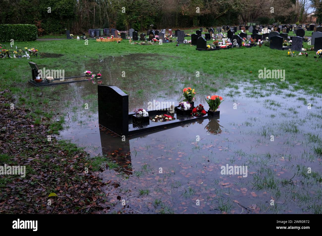 Wasserdurchtrennte Gräber auf dem Friedhof in Großbritannien Stockfoto