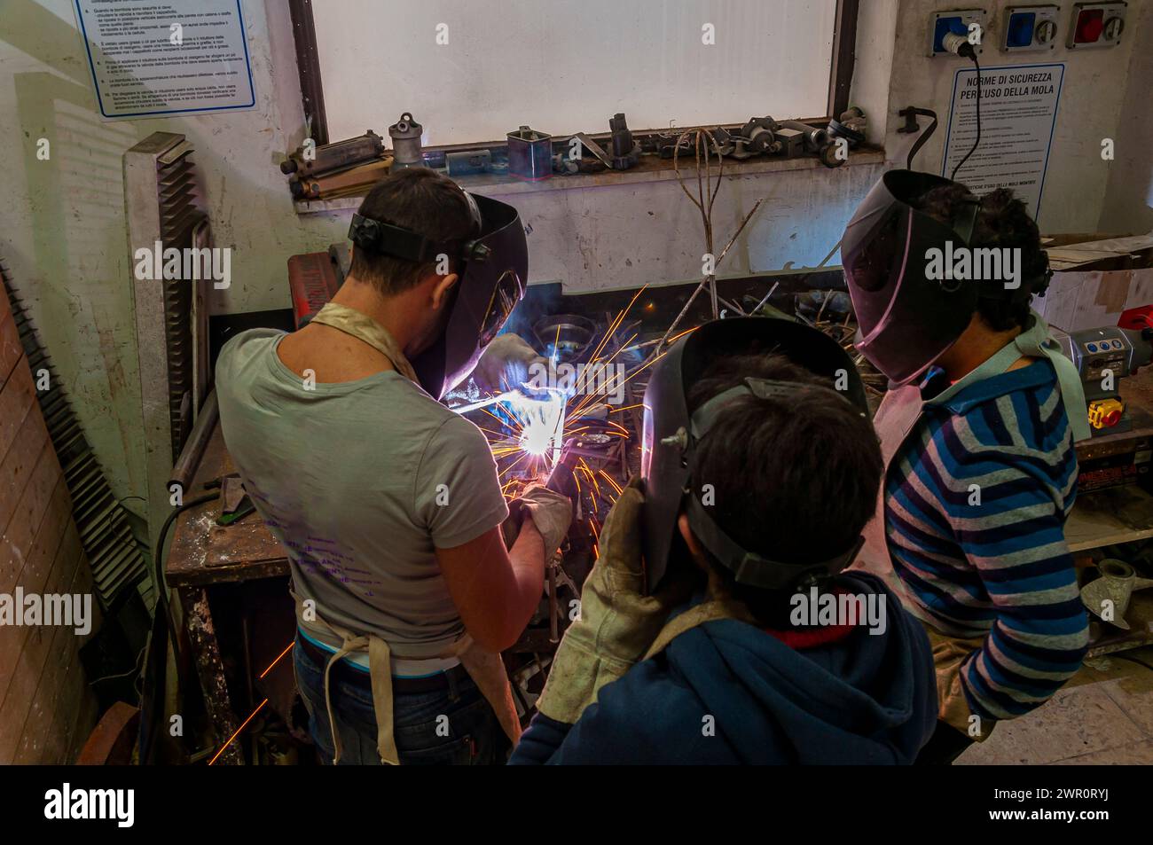 Eine Gruppe von Kindern lernt im Labor zu schweißen Stockfoto