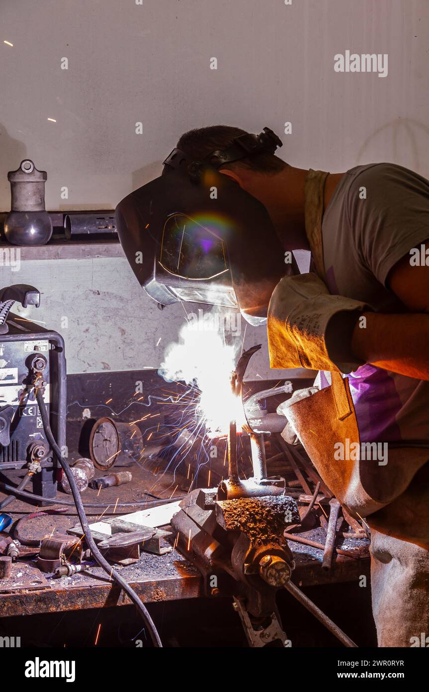 Junger Mann führt Schweißarbeiten in der Werkstatt durch Stockfoto