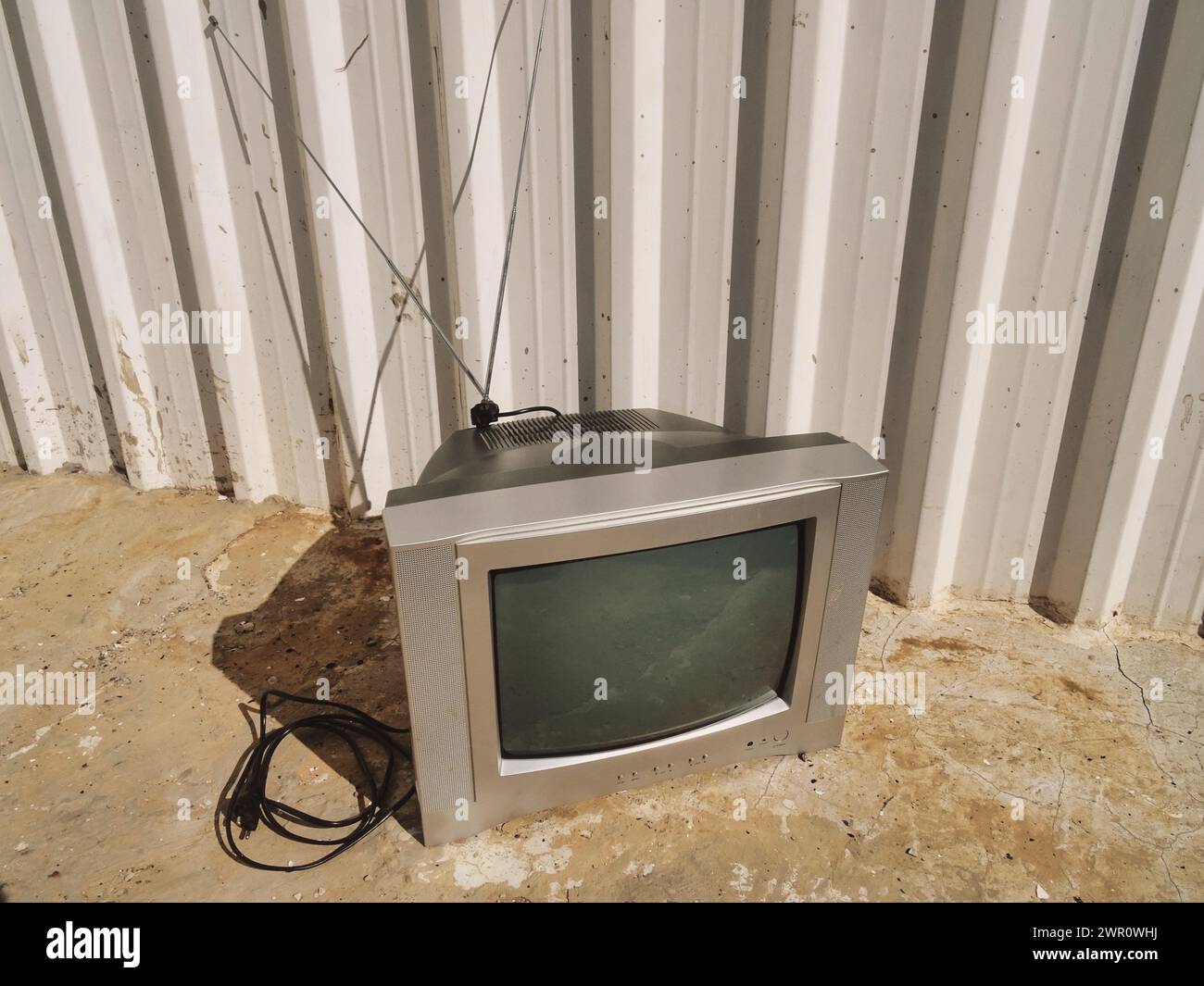 Außenanlage mit einem Vintage-Fernseher neben einem weißen Gebäude und einem grauen Fernseher Stockfoto