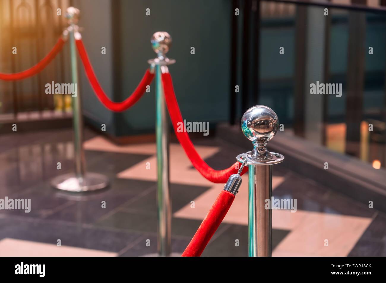 Seilzaun mit goldenen Säulen mit rotem Teppich für Prominente und Gäste einer teuren Veranstaltung. Stockfoto