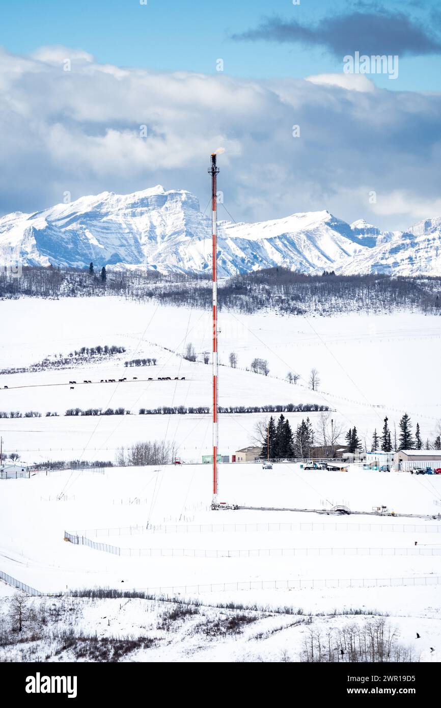 Rocky View County Alberta Canada, 2. März 2024: Flare Stack aus einer Gasanlage mit Blick auf die Kanadischen Rocky Mountains nach dem Jahr der UCP-Regierung von Alberta Stockfoto