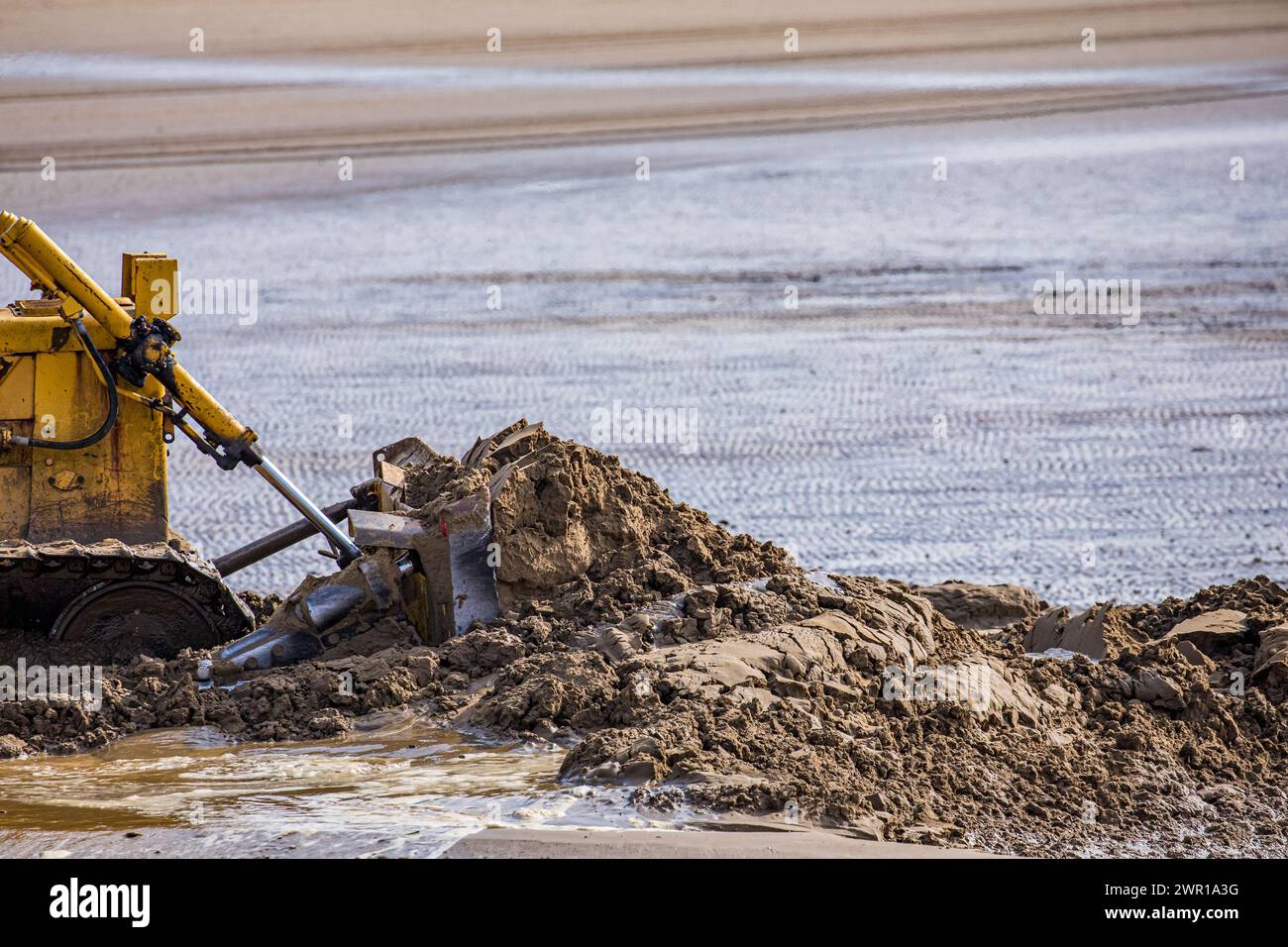 Der Bulldozer bewegt Sand am Weston Super Mare Beach, um den Auswirkungen der langen Küstendrift vor der Sommersaison entgegenzuwirken Stockfoto