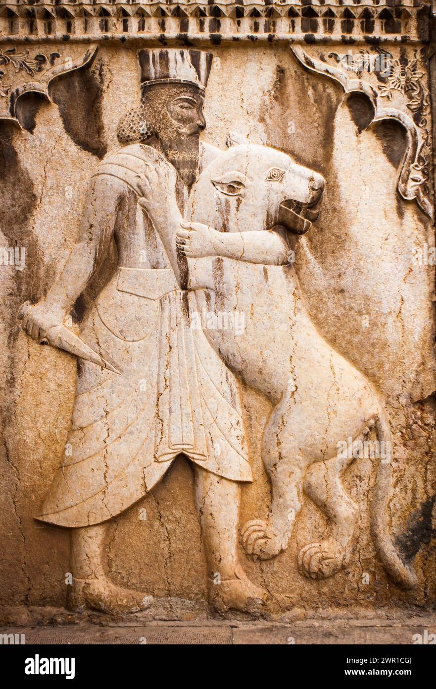 Altes Basrelief in Persepolis, Iran. Der Mensch tötet einen Löwen. Stockfoto