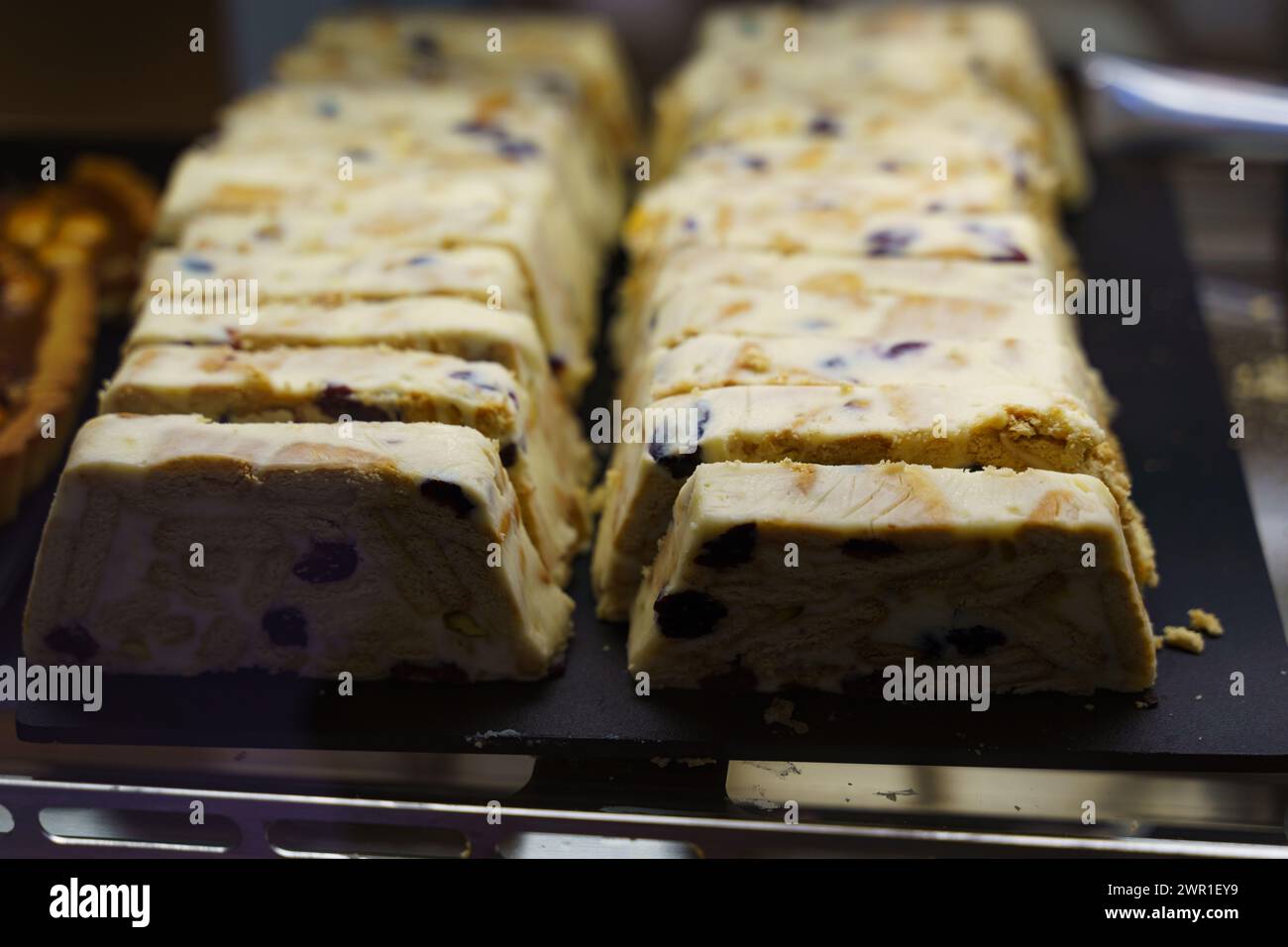 Reihen von frisch geschnittenem Keksteig mit Schokoladenchips, die in einer lokalen Bäckerei erworben werden können. Stockfoto