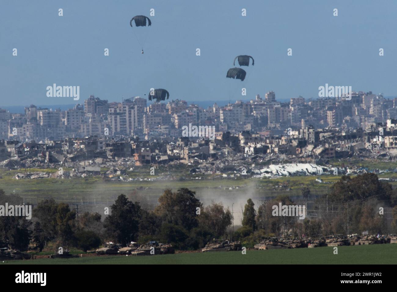 Süd-Israel, Israel. März 2024. Die C-130 der United States Air Force wirft humanitäre Hilfe per Fallschirm über dem nördlichen Gazastreifen ab, wie sie am 10. März 2024 aus dem Inneren Israels gesehen wird. Die USA und andere Länder geben weiterhin Nahrungsmittel und andere humanitäre Hilfsgüter für dringend bedürftige Palästinenser im Gazastreifen kurz vor Beginn des Heiligen Monats Ramadan ab, während Israels Krieg gegen die Hamas fortgesetzt wird. Foto von Jim Hollander/UPI Credit: UPI/Alamy Live News Stockfoto