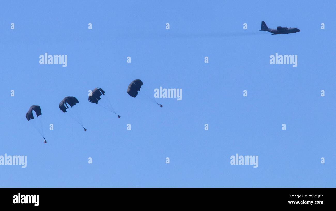 Süd-Israel, Israel. März 2024. Die C-130 der US-Luftwaffe wirft humanitäre Hilfe per Fallschirm über dem nördlichen Gazastreifen ab, wie sie vom Inneren Israels aus gesehen wird, am Sonntag, den 10. März 2024. Die USA und andere Länder geben weiterhin Nahrungsmittel und andere humanitäre Hilfsgüter für dringend bedürftige Palästinenser im Gazastreifen kurz vor Beginn des Heiligen Monats Ramadan ab, während Israels Krieg gegen die Hamas fortgesetzt wird. Foto von Jim Hollander/UPI Credit: UPI/Alamy Live News Stockfoto