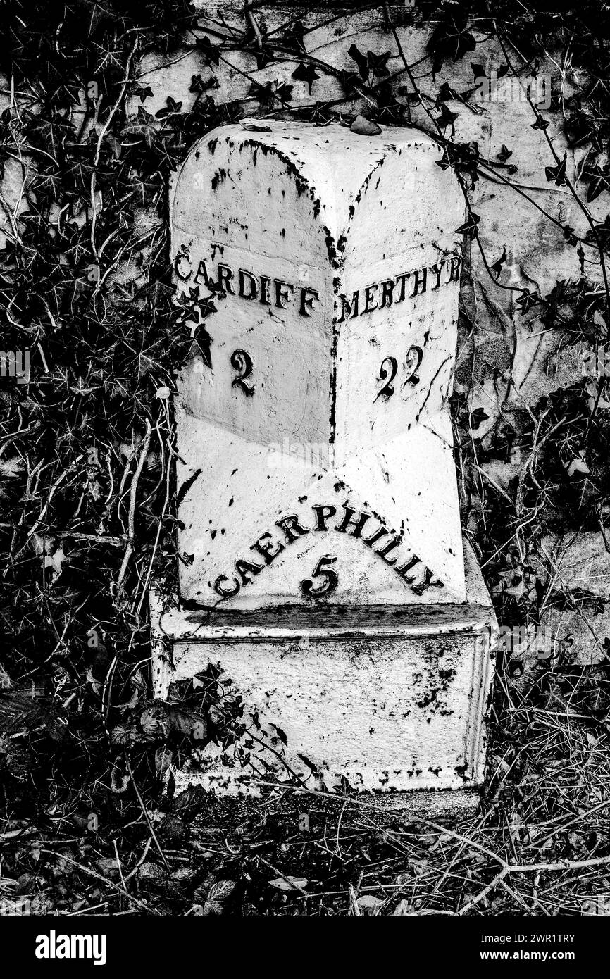 Ein alter Meilenstein aus Metall in Gabalfa, Wales, der die Distanzen nach Cardiff, Caerphilly und Merthyr Tydfil zeigt. Stockfoto