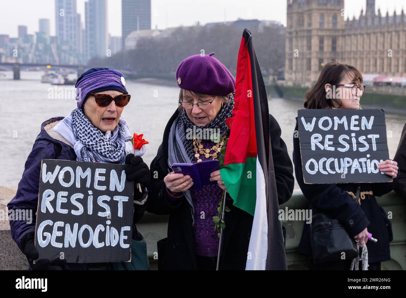 London, Großbritannien. März 2024. Frauen, die Schilder tragen, nehmen an einer Aktion zum Internationalen Frauentag Teil, die von Gruppen organisiert wird, darunter Eltern für Palästina, Eltern für das künftige Vereinigte Königreich, Familien der Extinction Rebellion und Globaler Frauenstreik, in Solidarität mit Frauen und gebärenden Menschen in Palästina. Die Aktion umfasste eine Zusammenkunft vor dem Mary Seacole Memorial im St. Thomas' Hospital, eine Zusammenlegung der Hände über die Westminster Bridge und die Verlegung von Blumen auf einer riesigen schwangeren Mutter-Sonnenvogel-Marionette auf dem Parliament Square. Quelle: Mark Kerrison/Alamy Live News Stockfoto