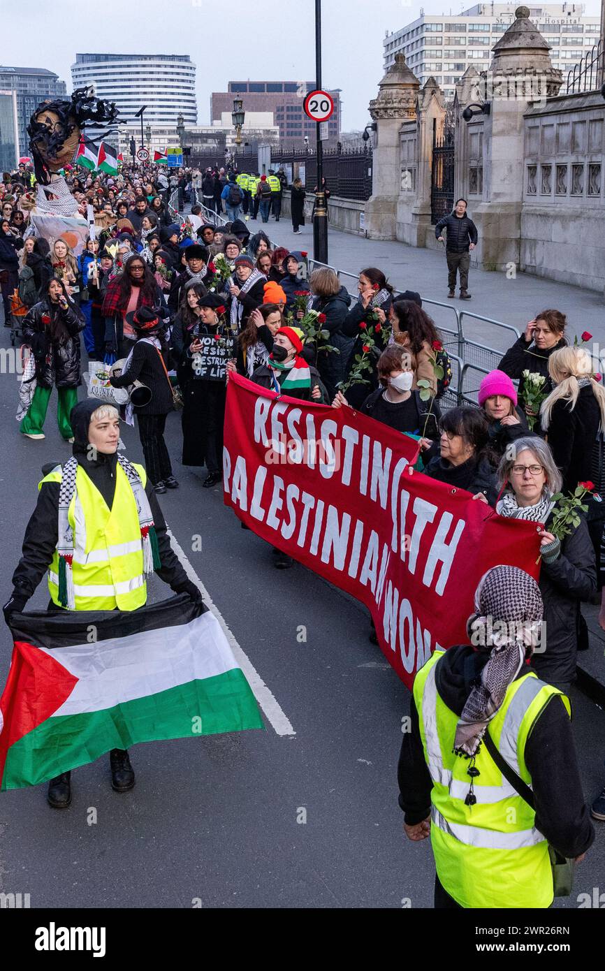 London, Großbritannien. März 2024. Frauen, Kinder und Verbündete nehmen an einer Aktion zum Internationalen Frauentag Teil, die von Gruppen organisiert wird, darunter Eltern für Palästina, Eltern für das künftige Vereinigte Königreich, Familien der Extinction Rebellion und Globaler Frauenstreik, in Solidarität mit Frauen und gebärenden Menschen in Palästina. Die Aktion umfasste eine Zusammenkunft vor dem Mary Seacole Memorial im St. Thomas' Hospital, eine Zusammenlegung der Hände über die Westminster Bridge und die Verlegung von Blumen auf einer riesigen schwangeren Mutter-Sonnenvogel-Marionette auf dem Parliament Square. Quelle: Mark Kerrison/Alamy Live News Stockfoto