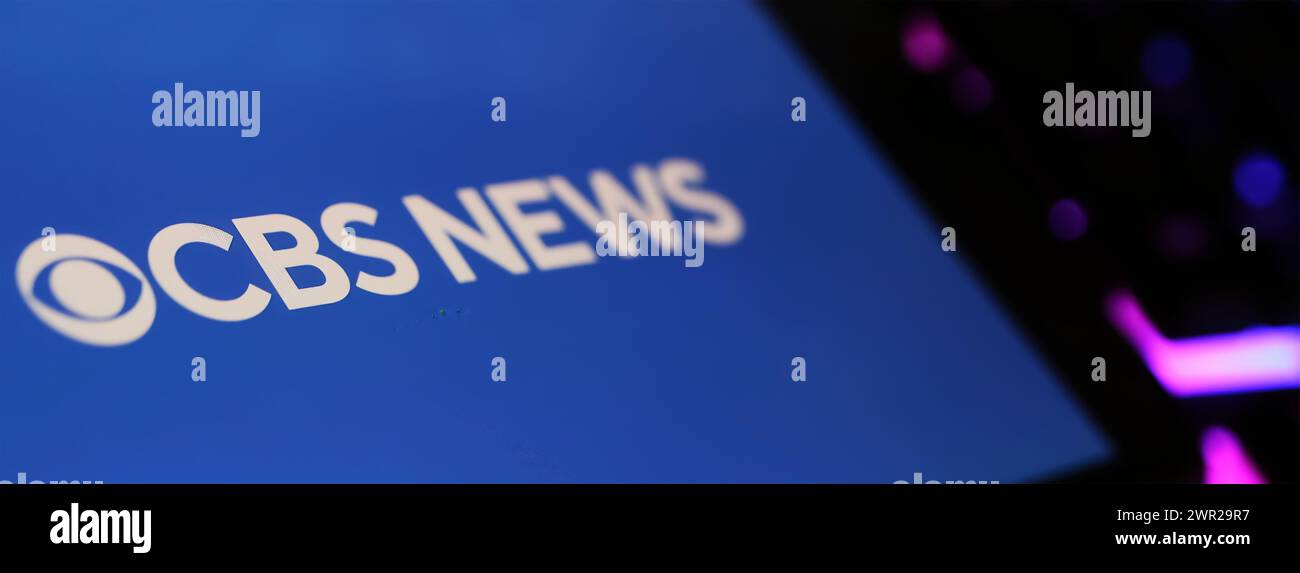 Viersen, Deutschland - 1. März. 2024: Nahaufnahme des Smartphones mit Logo-Schriftzug von CBS News auf Computertastatur Stockfoto
