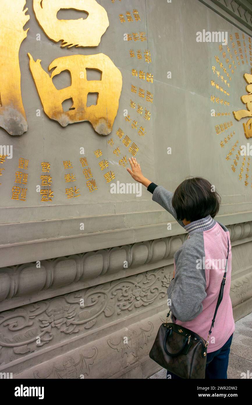 Chengdu, China, Sichuan, Chinesischer Tourist, Frau, von hinten berühren Sie den traditionellen buddhistischen Schild in Tempel, draußen, Besuch der Altstadt Stockfoto