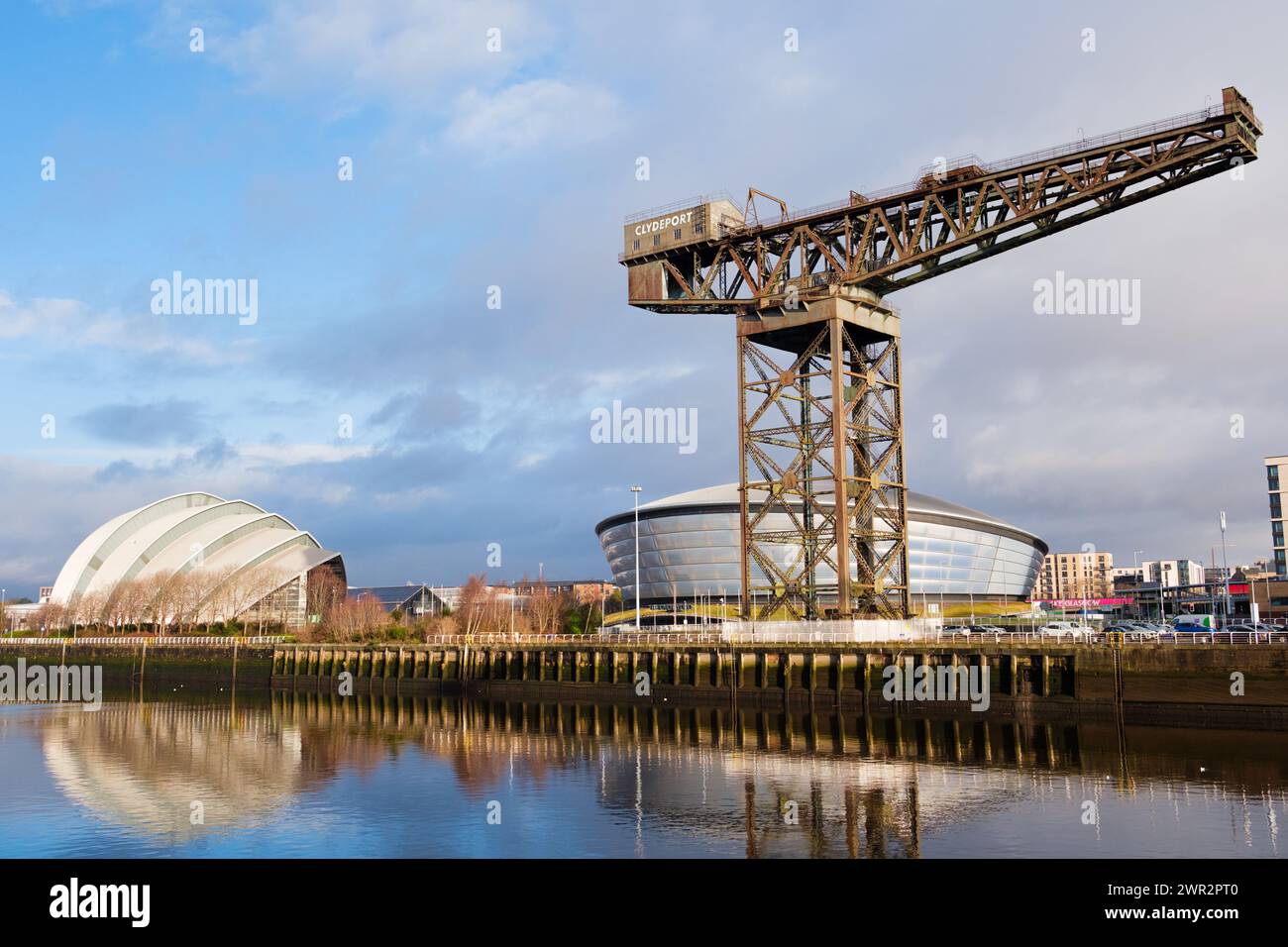 Glasgow Schottland: 13. Februar 2024: Finnieston Crane an einer sonnigen goldenen Stunde am Morgen. Ufer des Flusses Clyde Reflexion auf Wasser. Armadillo und Hydro Stockfoto