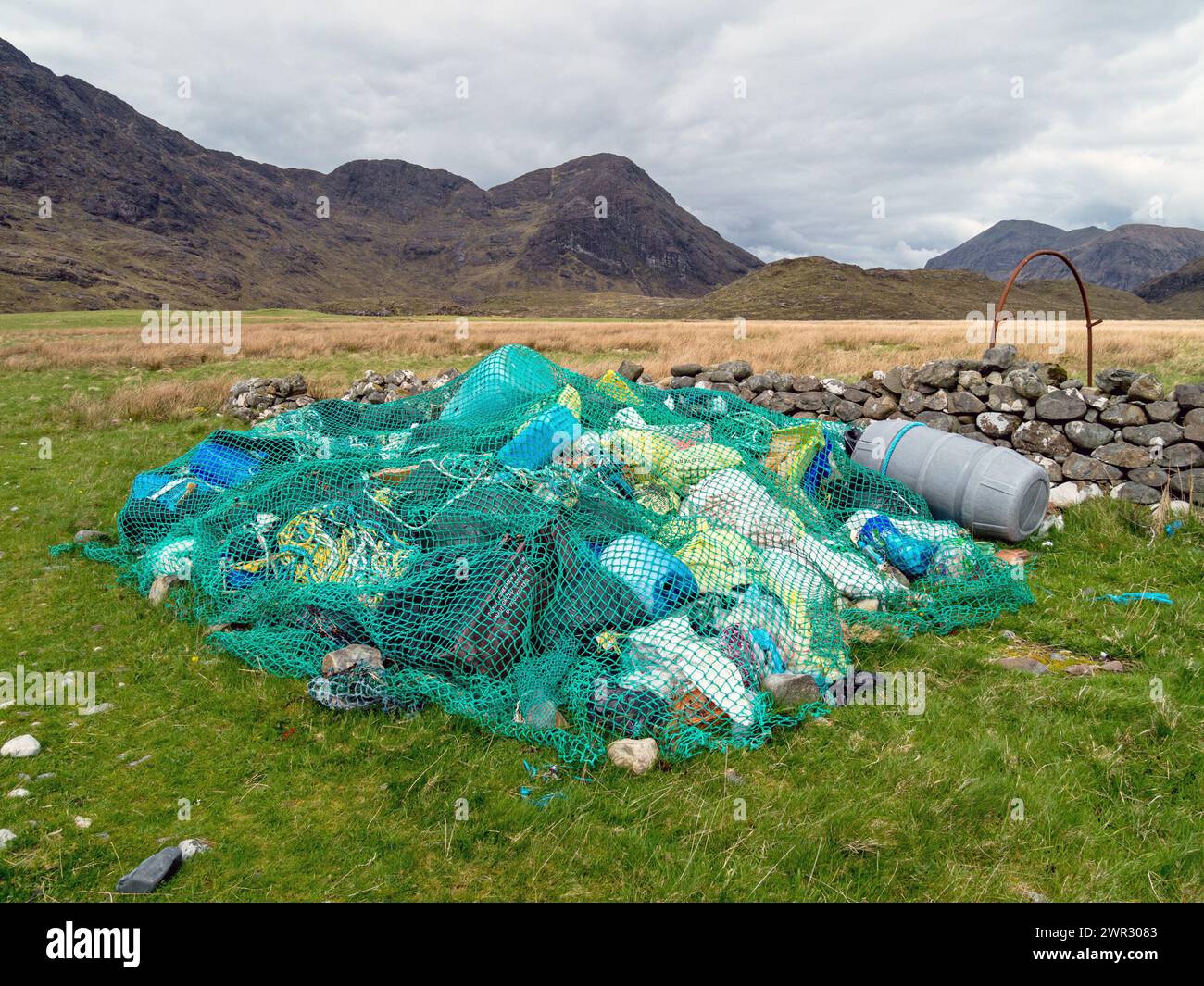 Sammlung von Strand Müll (Treibgut) unter alten Fischernetz an der Camasunary Bucht, Insel Skye, Schottland, Großbritannien Stockfoto
