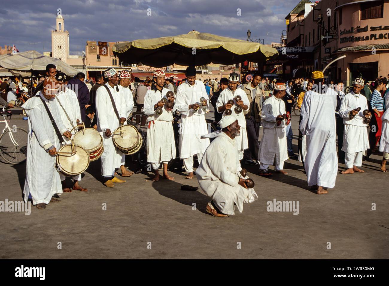 Marrakesch, Marokko. Gnaoua Musiker und Tänzer, Place Jemaa El-Fna. Cowrie Shell Dekorationen auf Caps. Die Metallcastanetten heißen qarqaba, die Stockfoto