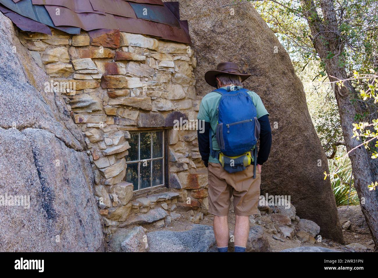 Alte Fenster und Dachschindeln in der Eagle Cliff Mine Hütte mit einem Wanderer im Joshua Tree National Park, Kalifornien Stockfoto
