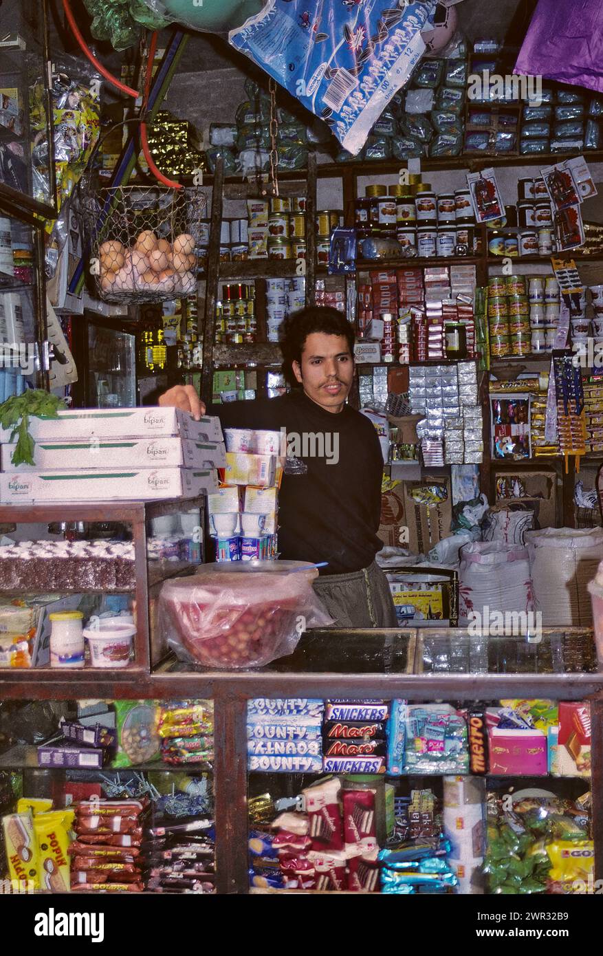 Fès, Marokko - Ladenbesitzer. Verkäufer von Süßigkeiten, Konserven, Lebensmitteln, Kleidung, Oliven, Eier, Marmelade, Verschiedene Artikel. Stockfoto