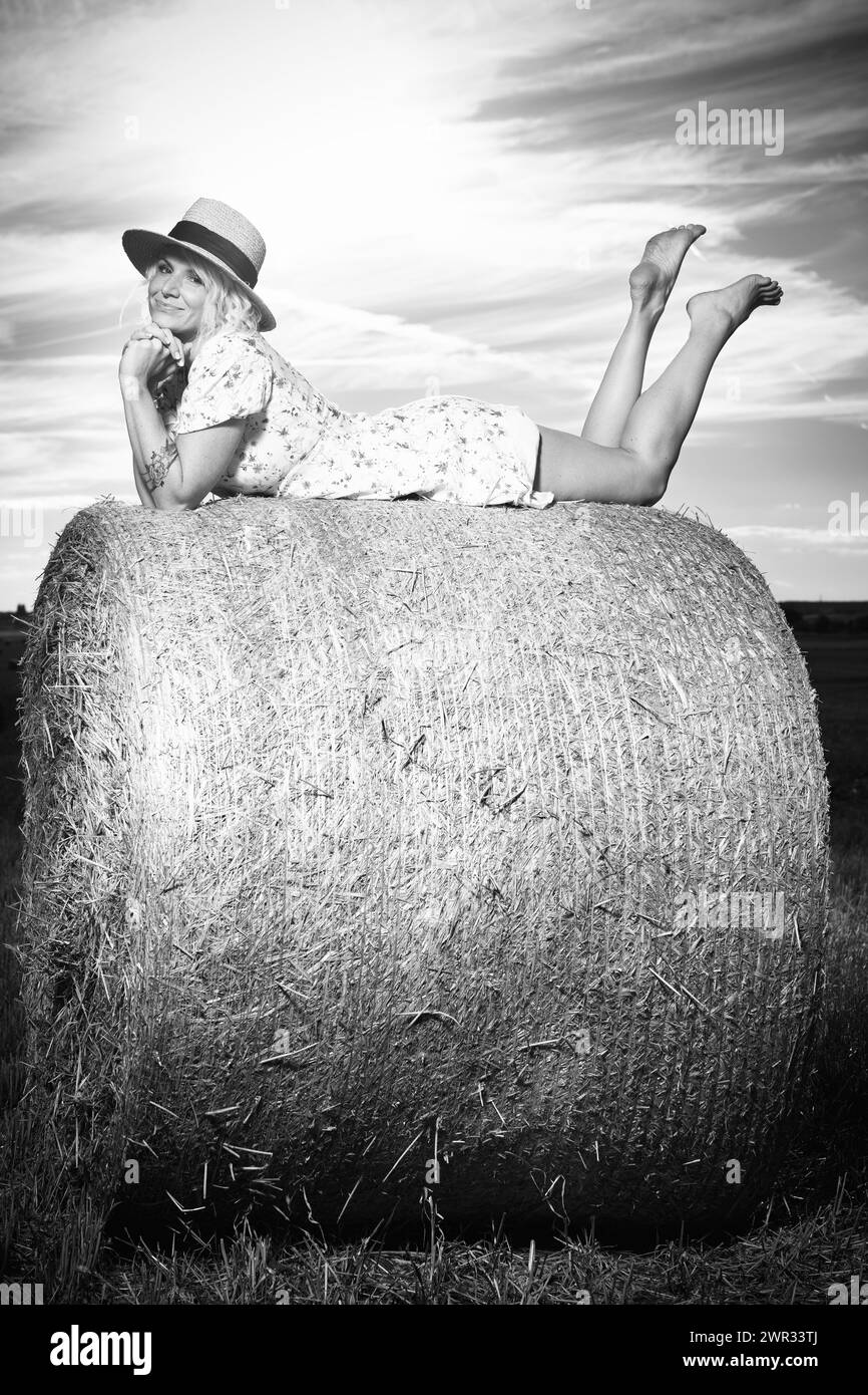 Einfarbiges Porträt einer hübschen Dame in Sommerkleidung, die auf dem Maisfeld posiert Stockfoto