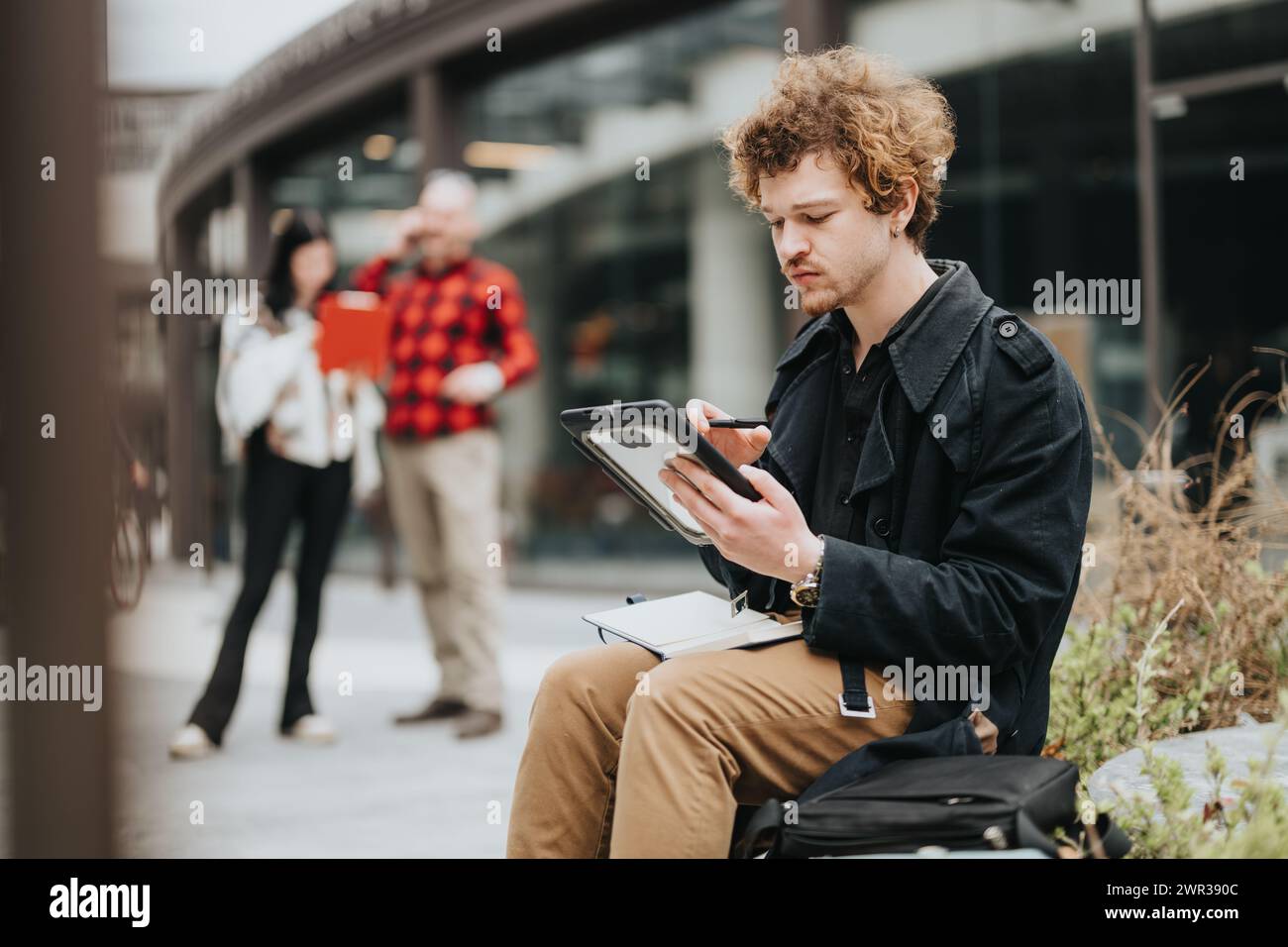 Unternehmer bei einem informellen Treffen im Freien, bei dem sie über digitale Tablets diskutieren Stockfoto