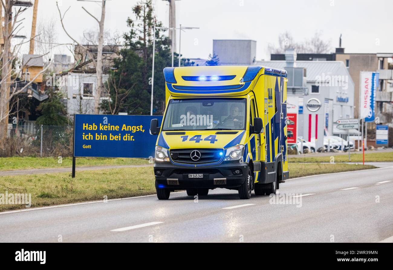 Ein Rettungswagen ist auf einer Hauptstraße mit Blaulicht und Sondersignal unterwegs. (Niederglatt, Schweiz, 28.01.2023) Stockfoto