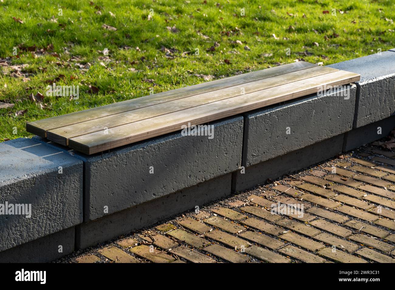 Moderne Holzbank auf Betonfundament im Außenbereich Stockfoto